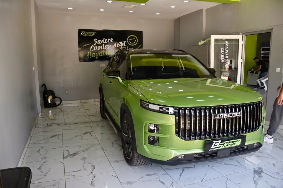 Atölyede yeşil SUV otomobilin ön çapraz görünümü